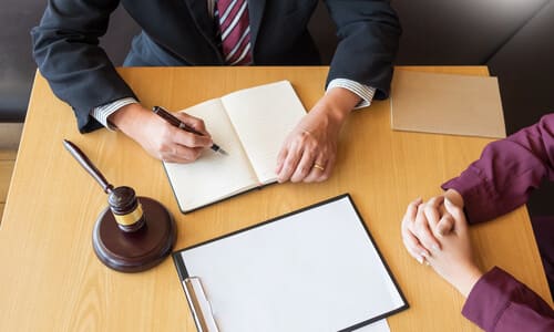 An overhead shot of a personal injury lawyer and a client building a case for a claim.